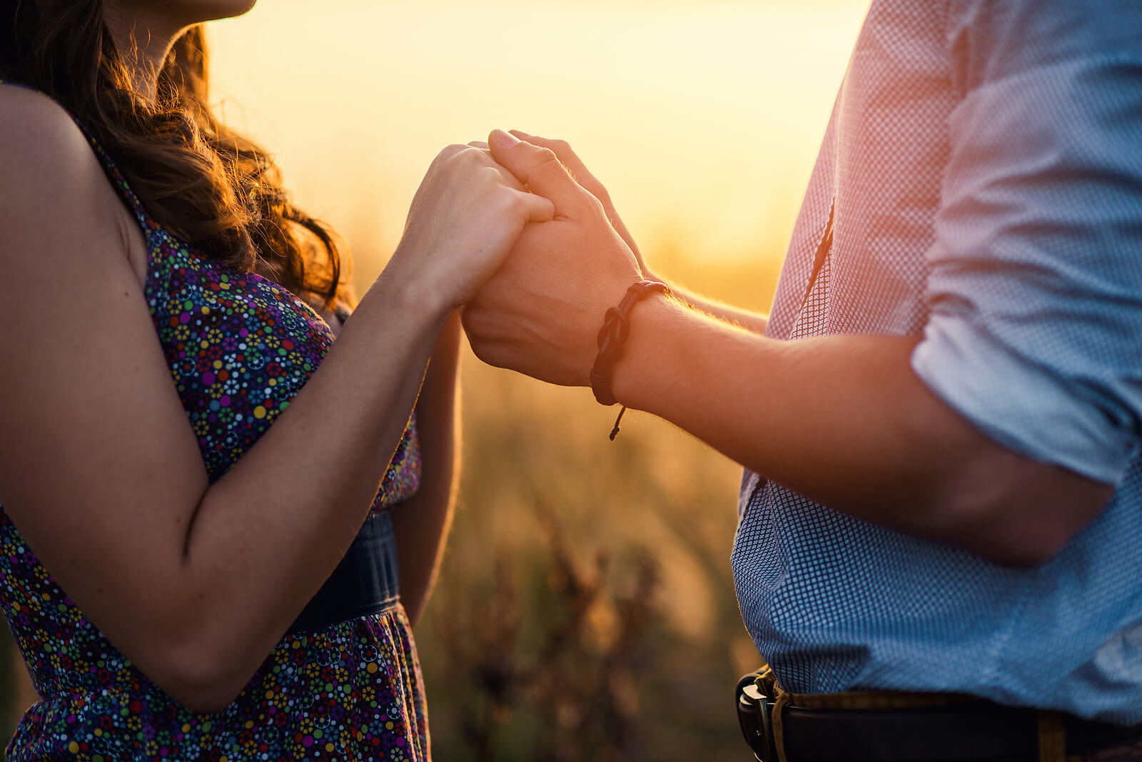 Image of a happy couple holding hands while looking at each other. Overcome the broken trust in your relationship after betrayal with the help of EMDR therapy in Wake Forest, NC.