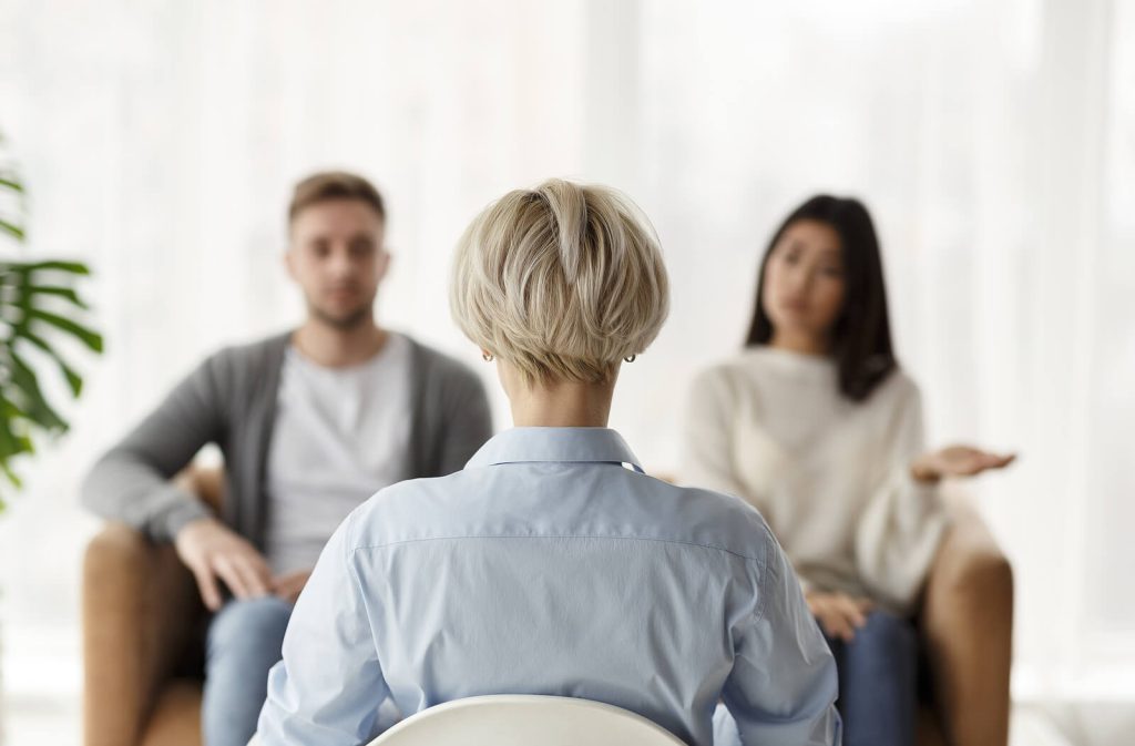 Image of a couple sitting on a couch across from a therapist. Begin to heal and rebuild trust after betrayal with the help of EMDR therapy in Wake Forest, NC.