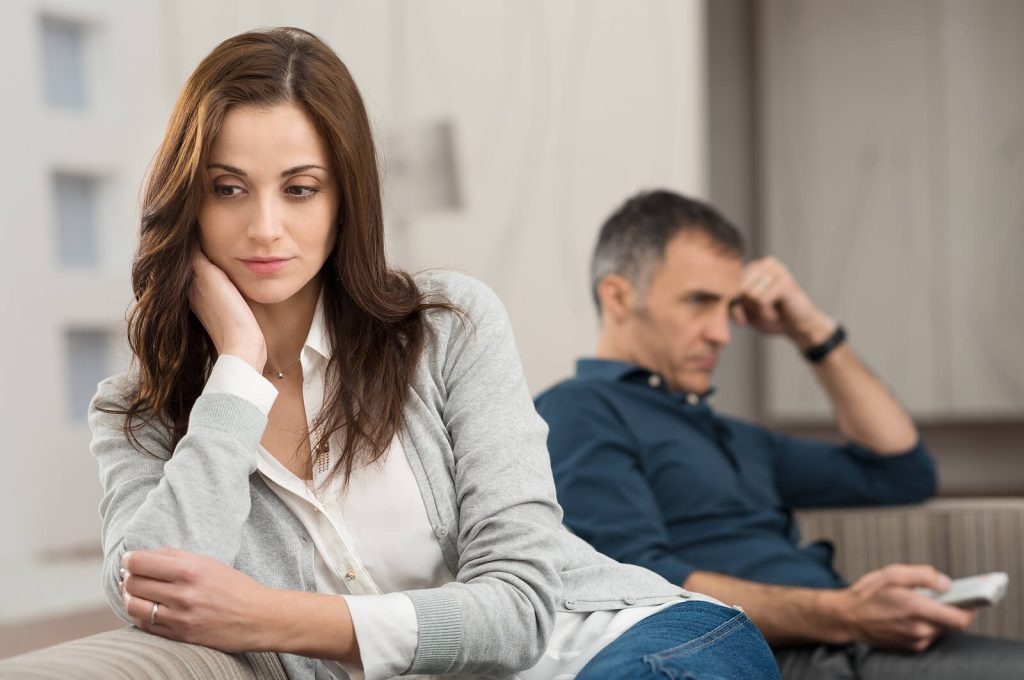 Image of an upset couple sitting on a couch facing away from each other. With the help of EMDR therapy in Wake Forest, NC you and your partner can begin to break unhealthy relationship patterns.