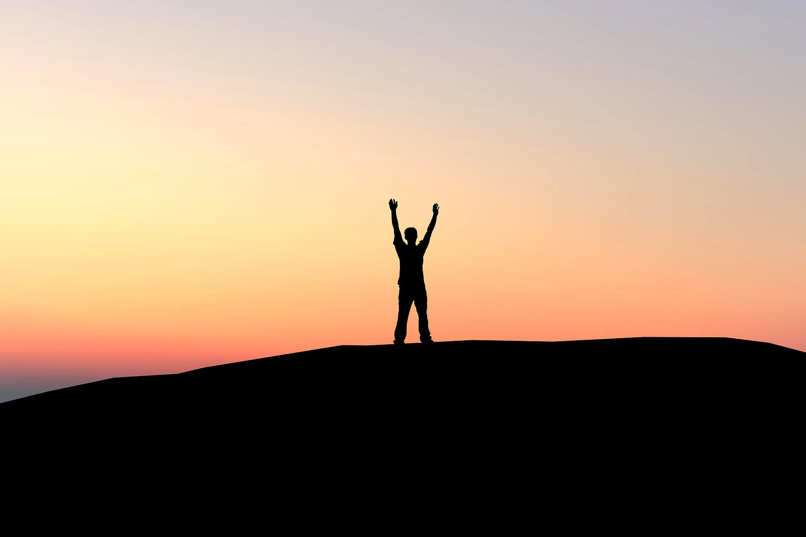 Image of a man standing on top of a hill with his arms spread out. If you find yourself struggling to overcome past trauma, discover how EMDR therapy in Raleigh, NC can help you.