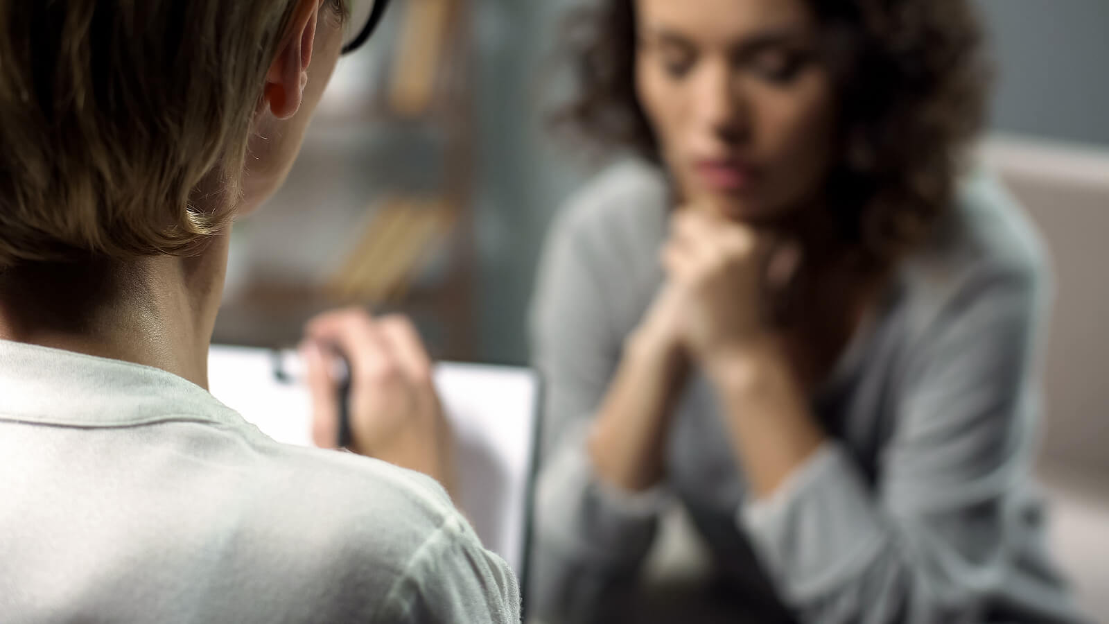 Image of an upset woman sitting on a chair opposite a woman with a clipboard. With the support of a skilled EMDR therapist in Raleigh, NC you can begin working on processing and healing from your trauma.