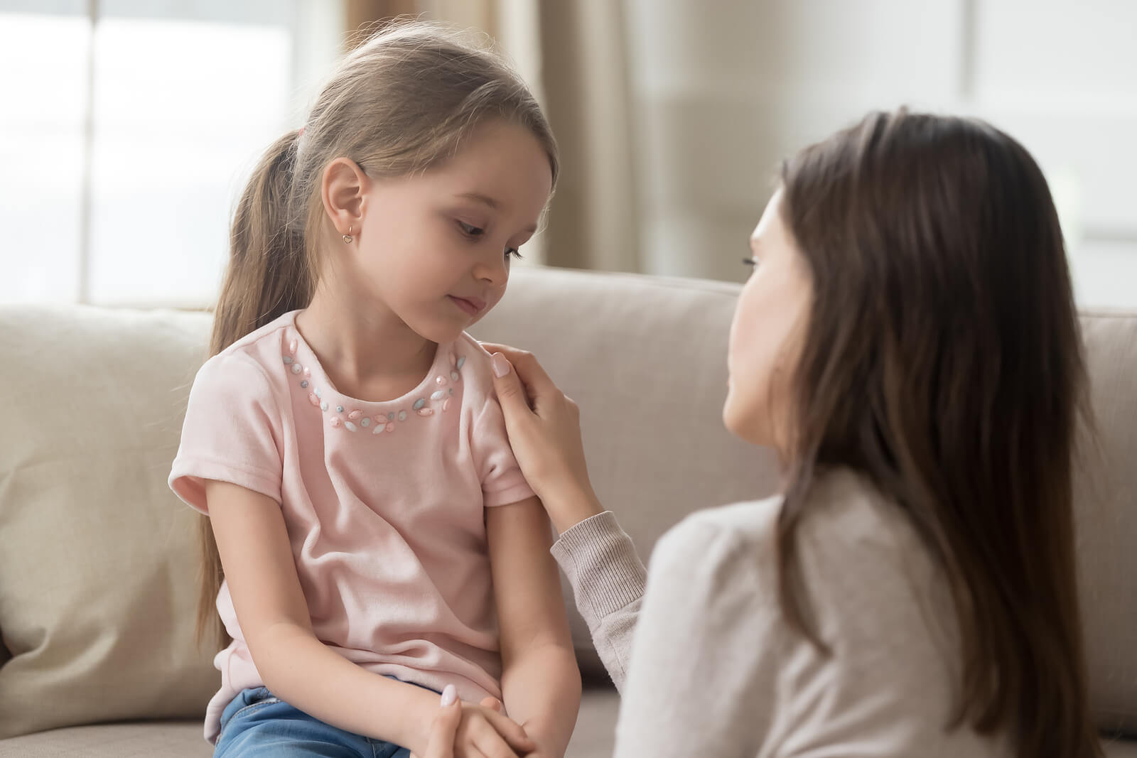 mom talking to little girl | emdr therapy in raleigh, nc | emdr therapist in raleigh, nc | emdr therapy for children | emdr and children | 27607 | 27614 | 27613 Image of a little girl sitting on a couch talking to her mom. Start seeing positive improvements in your child's behavior with the support of EMDR therapy in Raleigh, NC.