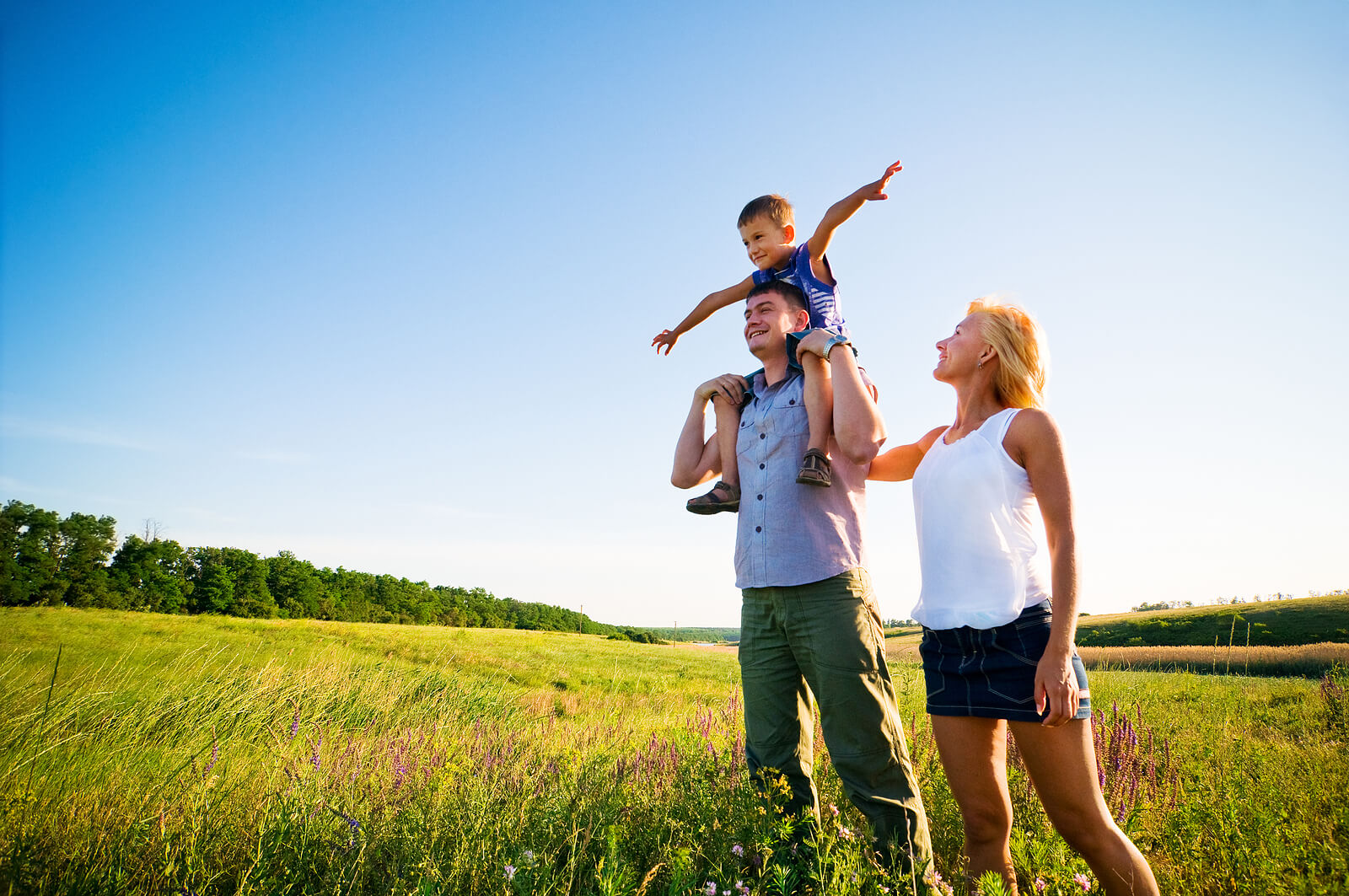 happy family in field | emdr therapy in raleigh, nc | emdr therapist in raleigh, nc | emdr therapy for children | emdr and children | 27616 | 27609 | 27604 A happy family standing in a field on a sunny day. EMDR therapy in Raleigh, NC can help your child begin to process their emotions and unresolved trauma. Start seeing positive changes in your child!
