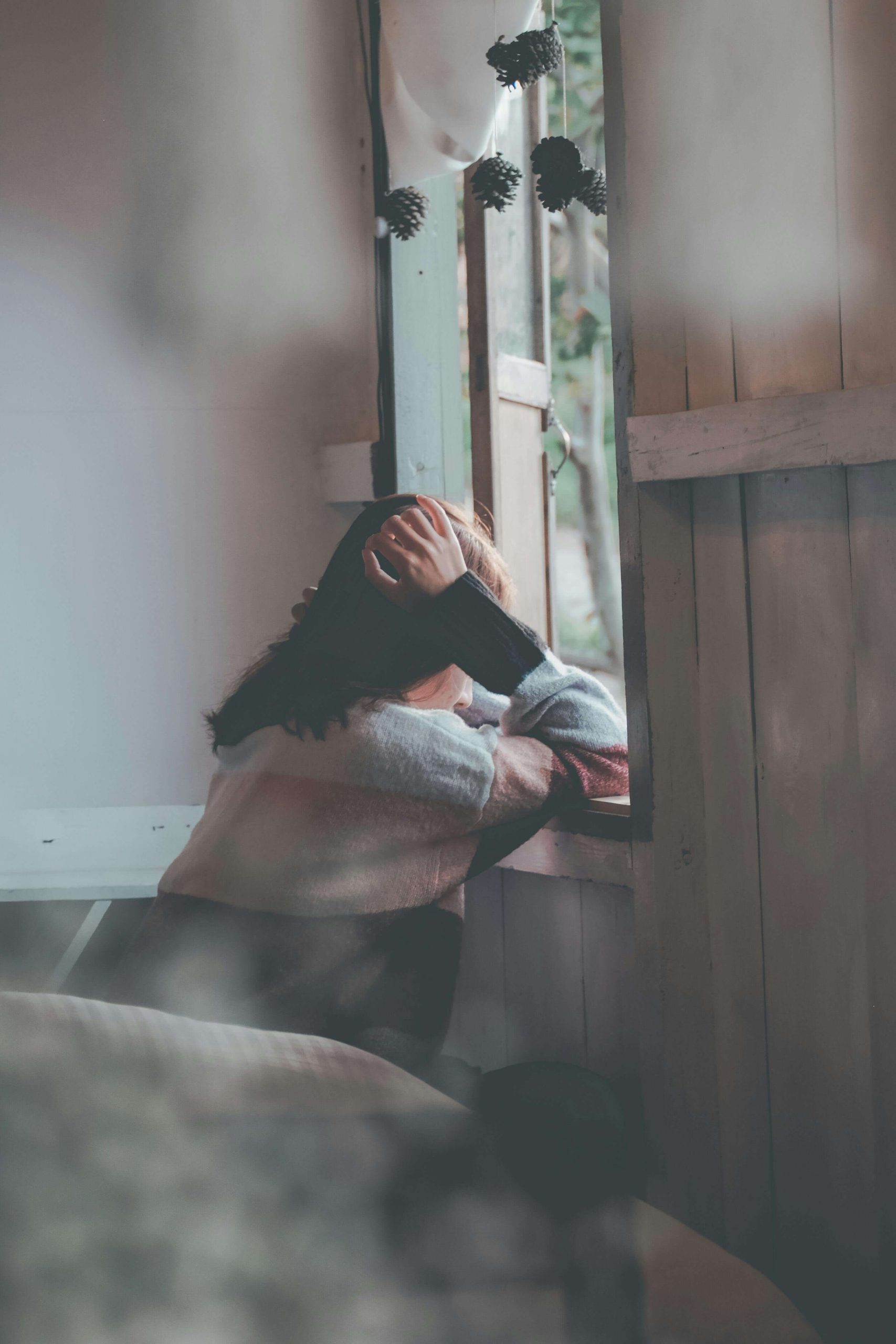 sad woman by window | emdr therapy in raleigh, nc | emdr therapist | emdr trauma therapy | emdr for couples | Five Points | Boylan Heights | Brier Creek Sad woman looking out a window. With the support of EMDR therapy in Raleigh, NC you can begin processing your emotions after an emotional breakup in healthy ways.