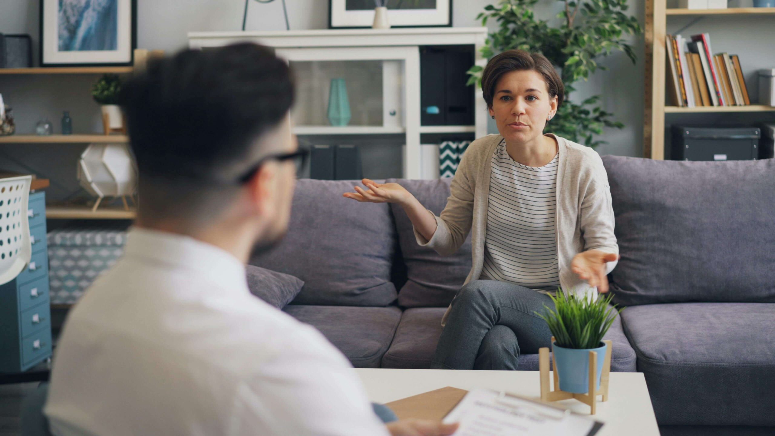 woman in therapy | emdr therapy in raleigh, nc | emdr therapist | emdr trauma therapy | emdr for couples | Hayes Barton | North Hills | Cameron Village Woman sitting on a couch speaking to a male therapist. By working with a skilled EMDR therapist in Raleigh, NC you can begin to cope and process your feelings in healthy ways after a divorce.